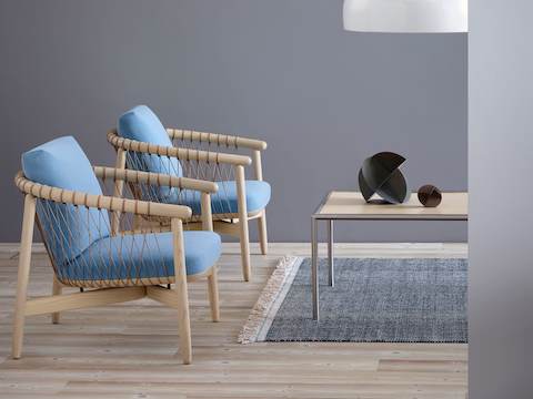 Two Crosshatch lounge chairs with light blue fabric and light wood frames, positioned next to a rectangular Full Round coffee table.
