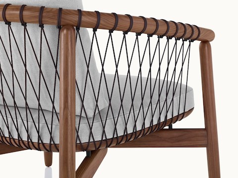 Close-up on the back and side of a Crosshatch lounge chair, showing the parachute cords that form a lattice to support the wood frame.