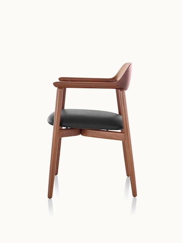 Side view of a Crosshatch Side Chair with a black leather seat pad and a wood frame in a medium finish.
