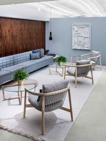 A lounge featuring three round Loophole occasional tables, a light blue Tuxedo Classic Lounge Seating sofa, and three light gray Crosshatch Chairs.