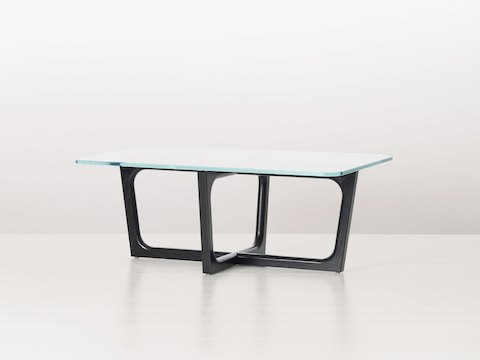 A rectangular Loophole coffee table with a 24-inch-deep glass top and black wood base, viewed at an angle.