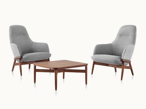 Two high-back Reframe lounge chairs with light gray upholstery on either side of a Reframe occasional table with a medium finish.