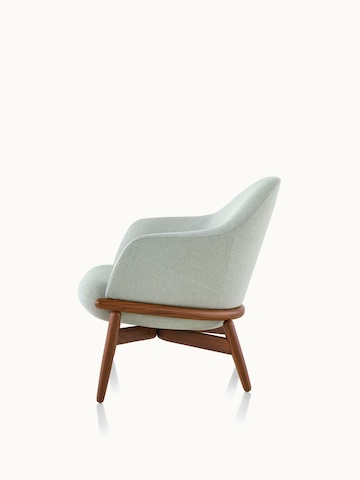 Side view of a mid-back Reframe lounge chair with light green upholstery and a wood frame in a medium finish.