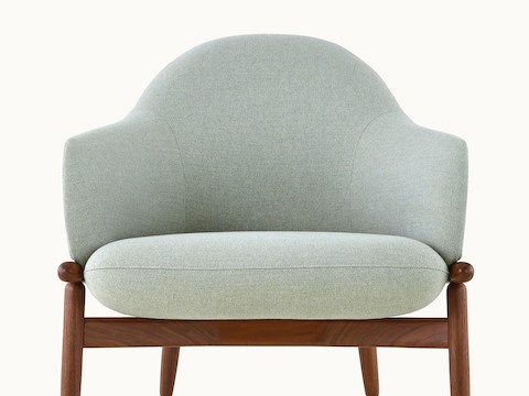 The upper half of a mid-back Reframe lounge chair with light green upholstery, viewed from the front.