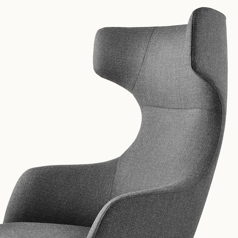 Side view of a wingback Reframe lounge chair with dark gray upholstery.
