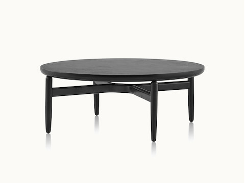 A round Reframe occasional table with a black wood finish.