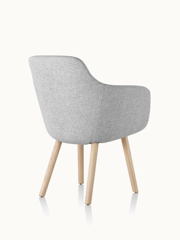A Saiba Side Chair with light gray upholstery and wood legs in a light finish, viewed from behind at an angle.