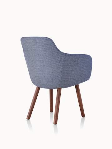 A Saiba Side Chair with blue upholstery and wood legs in a medium finish, viewed from behind at an angle.