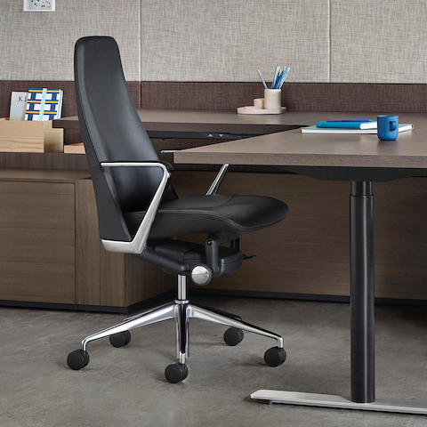 Partial view of an executive office featuring a black leather Taper office chair.