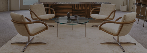 Four Full Loop Lounge Chairs around a glass and metal Claw Table in front of a Domino Credenza in an office lounge setting.