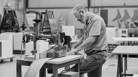 Black-and-white image of a Geiger craftsman operating a woodworking machine.