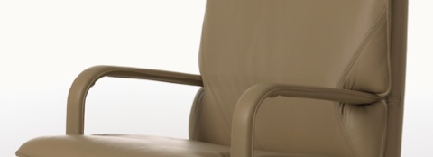 Partial view of a brown leather Attaché Chair, focusing on the arms. Partial view of a brown leather Attaché Chair, focusing on the arms.