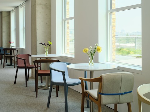 Collection of Lijn Side Chairs and Armchairs designed by Carole Baijings for Geiger in assorted finishes shown at an angle in a café setting.