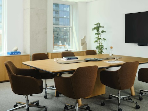 Ascent Conference Table designed by EOOS for DatesWeiser in Natural Rift Cut Oak with a trapezoid top shown at an angle surrounded by Geiger Saiba chairs and two JD Credenzas.