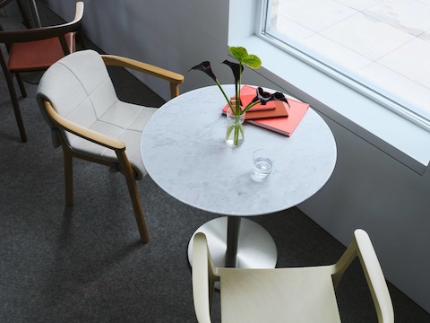 Lijn Armchairs by Carole Baijings for Geiger, shown in veneer and quilted wrap variations with NL1 Table, viewed from above with notebooks and a vase of flowers on the table in the Geiger DatesWeiser Chicago Showroom.