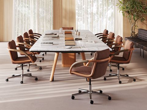 Ascent Conference Table designed by EOOS for DatesWeiser, shown in White Carrara Marble with a Natural Rift Cut Oak base, with Full Loop Chairs viewed from the side in a boardroom setting.
