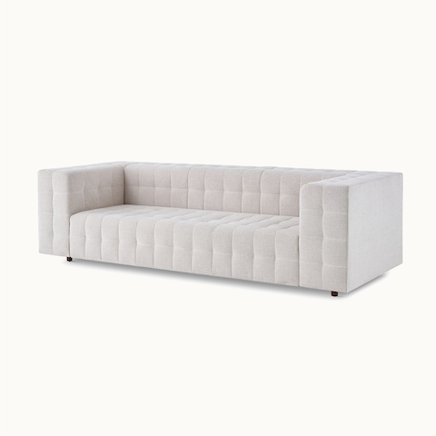 Rapport Sofa upholstered in a light textile with walnut legs viewed from an angle.