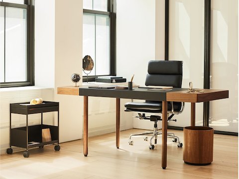 A corporate office setting with the Leatherwrap Sit-to-Stand Desk and Eames Soft Pad chair.