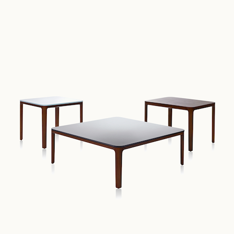 Three A Line occasional tables, including two square tables with glass tops and one rectangular table with a veneer top, all with solid wood legs.