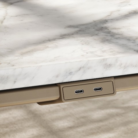 Detail of Ascent Conference Table by EOOS for DatesWeiser in White Carrara marble showing edge with power access in silk bronze viewed at an angle.