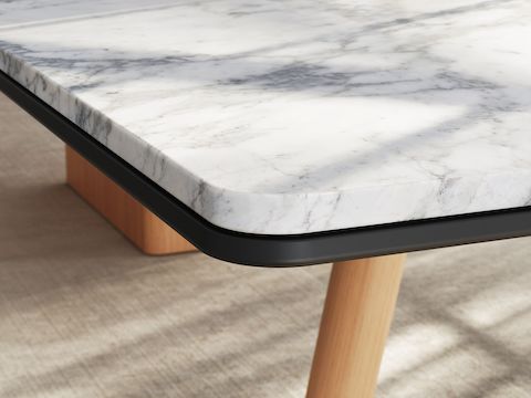 Detail of Ascent Conference Table by EOOS for DatesWeiser showing protective edge in White Carrara marble with natural rift cut oak base viewed at an angle.