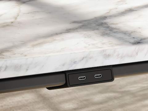 Detail of Ascent Conference Table by EOOS for DatesWeiser showing edge power access in White Carrara marble with natural rift cut oak base viewed at an angle.