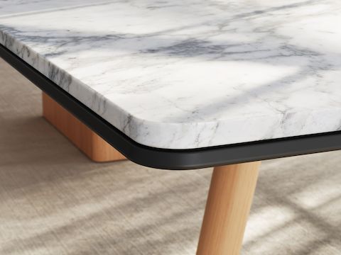 Detail of Ascent Conference Table by EOOS for DatesWeiser showing protective edge in White Carrara marble with natural rift cut oak base viewed at an angle.