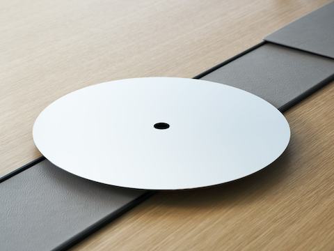 Detail view of the Ascent Conference Table, designed by EOOS for DatesWeiser, shown in Natural Rift Cut Oak with the power trough covered in Prone leather in Lute and an AV platform.