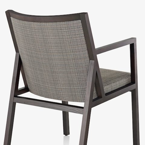 An Ascribe side chair with gray upholstery, viewed from behind at an angle.