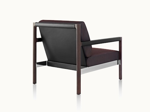 A Brabo club chair with dark brown upholstery, a black leather sling, metal accents, and an exposed wood frame, viewed from behind at an angle.