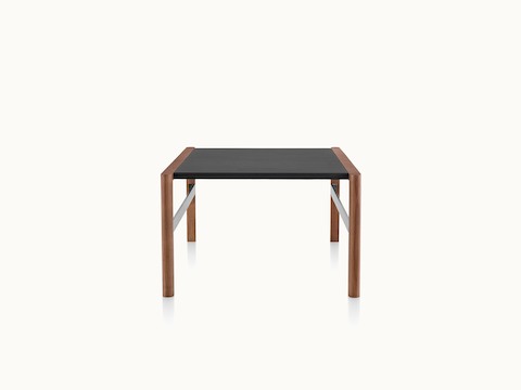A Brabo side table with a black leather-wrapped top, walnut frame, and metal frame supports, viewed from the side.