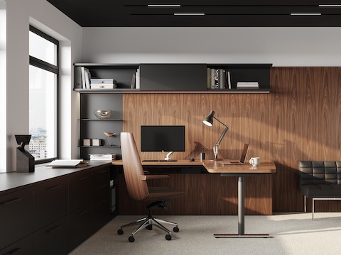Two adjacent workstations featuring Clamshell office chairs with veneer shells that coordinate with the wood finish on the wall, surfaces, and storage.