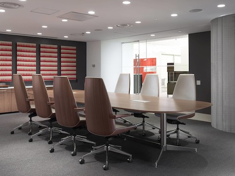 Angled view of a low-back Clamshell office chair with arms and white leather upholstery.