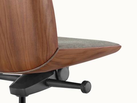 Close-up of a Clamshell office chair, viewed from behind to show the veneer shell with a medium finish.