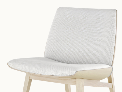 Angled view of a low-back Clamshell Lounge Chair with off-white fabric upholstery and light-ash legs. Angled view of a low-back Clamshell Lounge Chair with off-white fabric upholstery and light-ash legs.