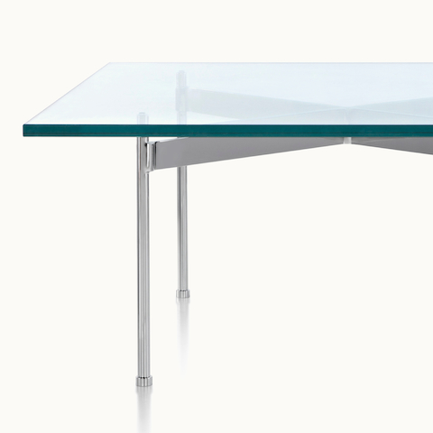Partial view of a square Claw occasional table, showing the metal cross brace that grasps the tubular legs beneath the glass top.