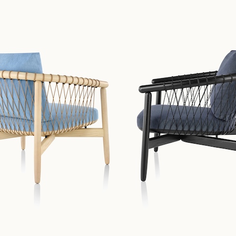 A Crosshatch lounge chair with light blue fabric and a light wood frame next to a Crosshatch lounge chair with dark blue fabric and a black frame.