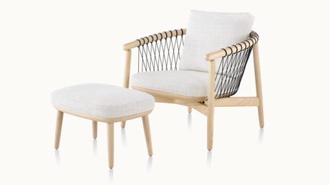 Angled view of a Crosshatch lounge chair and ottoman with off-white fabric and a light wood frame.