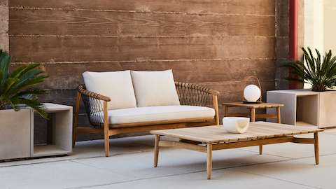 Crosshatch Outdoor Settee with Side Table and Rectangular Coffee Table in an environmental setting.