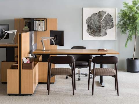 A semi-private office with a height-adjustable peninsula desk, black leather Saiba office chair, and two Crosshatch Side Chairs.