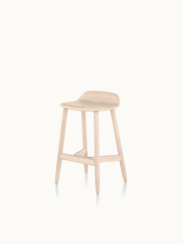 Angled view of a counter-height wood Crosshatch Stool with a light finish.