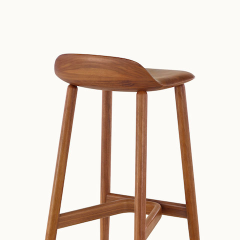 A wood Crosshatch Stool with a medium finish, viewed from behind to show the low backrest.