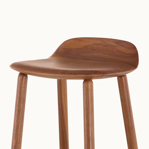 Close-up on the seat of a wood Crosshatch Stool with a medium finish, showing the rounded edges.