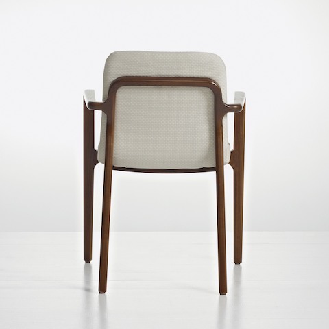 A Deft side chair with arms and ivory-colored fabric, viewed from behind to show the exposed wood frame.