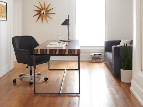 A private office featuring a Domino Desk, a Bumper Chair, and Rapport Settee.