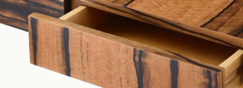A close up of an open drawer of a Domino Desk with wood top and metal base.
