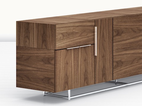 Partial angled view of a Domino Storage credenza, showing a medium wood finish on all sides.