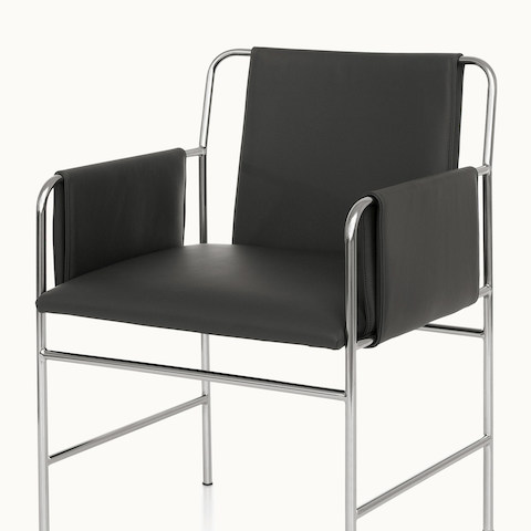 Angled view of an Envelope side chair with black leather upholstery and a tubular steel frame.