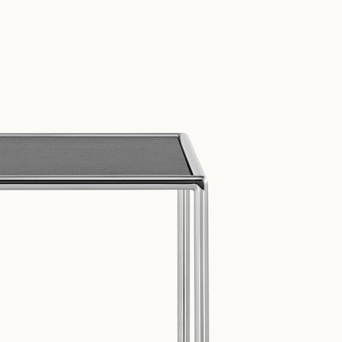Partial view of a square Full Round side table, focusing on the tubular metal frame.