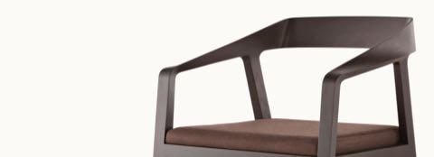 Close-up of the ribbon-like piece of wood that forms the arms and back of a black Full Twist Guest Chair.